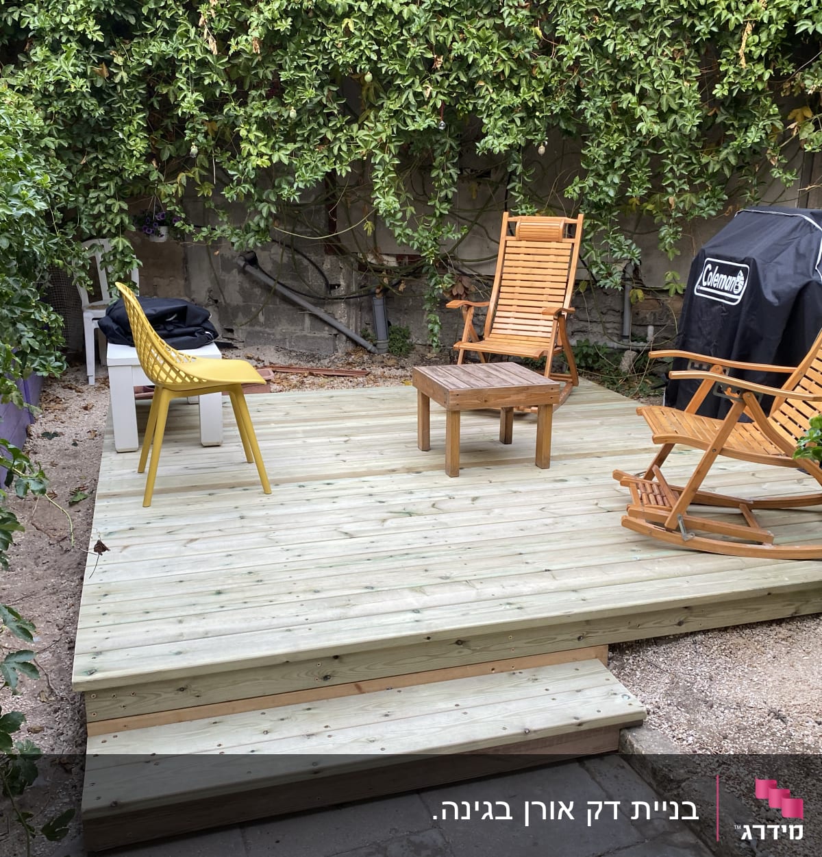 דק עץ עם כיסאות נדנדה ושולחן קטן בגינה